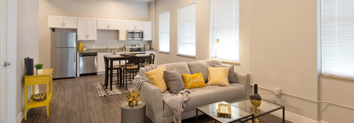 This image displays a living room and kitchen at Hershey Lofts in Muscatine, Iowa